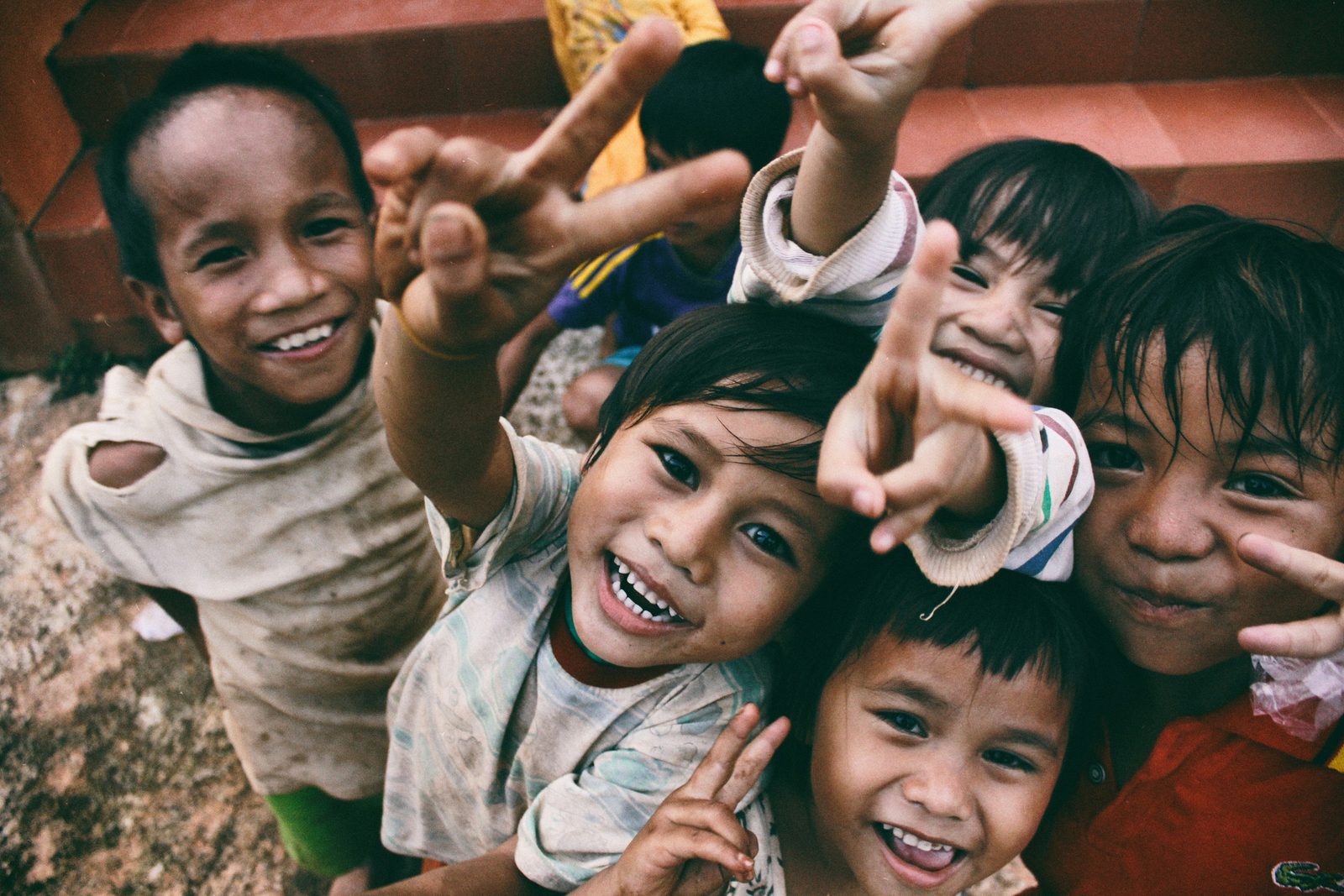 Children smiling and waving at a community youth program